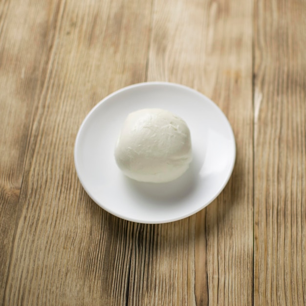 Mozzarella on a plate on a wooden background