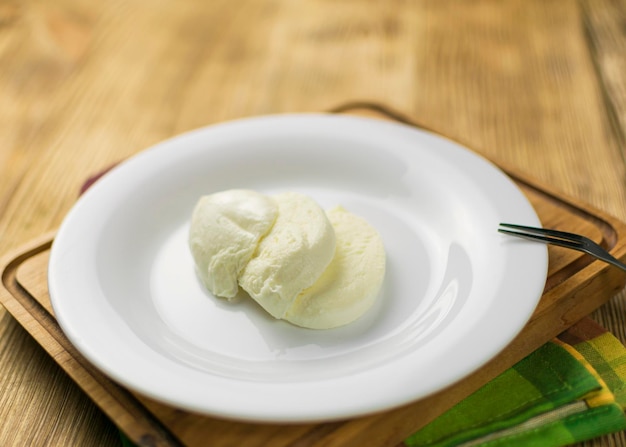 Mozzarella on a plate on a wooden background