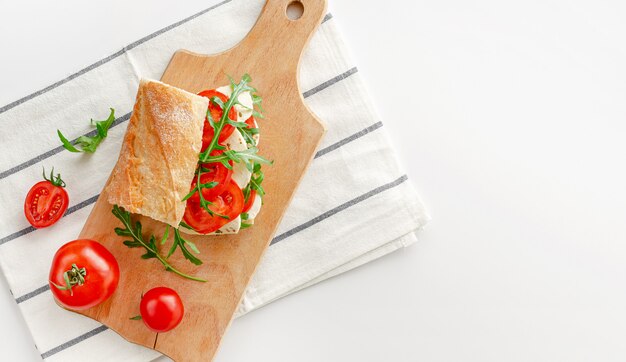 木製のまな板にモッツァレラチーズのサンドイッチ。イタリアのスナックのコンセプト。平面図、オーバーヘッド。コピースペース