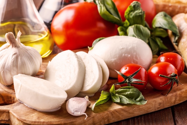 Mozzarella, tomaten, knoflook en basilicum op tafel