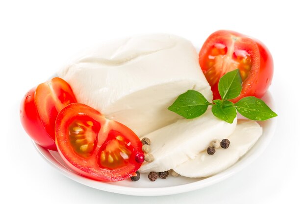 Mozzarella tomatoes and basil leaves on white background