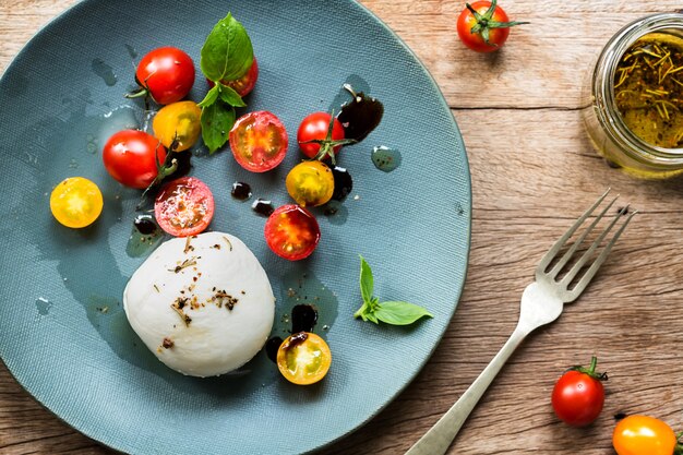 Mozzarella with Cherry Tomatoes salad on a wooden board