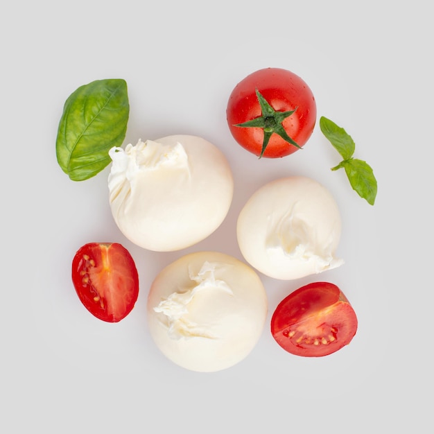 Mozzarella with tomatoes butter and basil on a white background