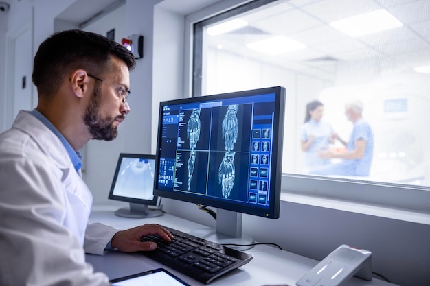 MRI diagnostic center control room and neurologist examining patient Xray images on large display