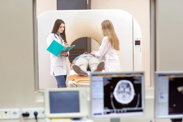 MRI-machine en schermen met arts en verpleegkundige