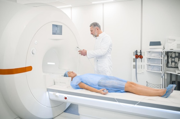 MRI Male doagnostic specialist preparing the patient to MRI