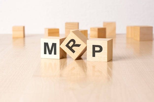 MRP аббревиатура деревянных блоков с буквами на сером фоне, отражающая надпись на зеркальной поверхности стола, выборочный фокус
