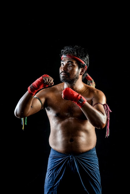 Muai thai boxer man trainings. studio shot on black