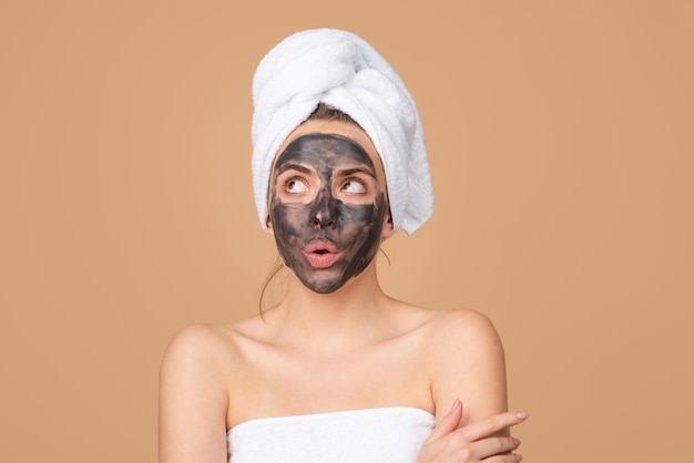 Mud facial mask face clay mask spa beautiful funny woman with cosmetic mud facial procedure spa heal