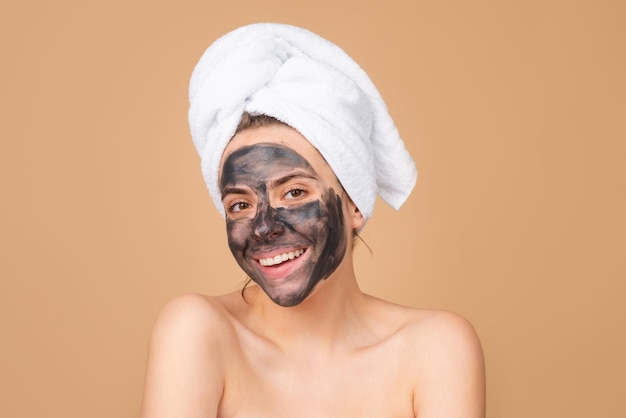 Mud facial mask face clay mask spa beautiful smiling woman with cosmetic mud facial procedure spa he