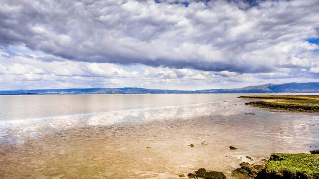 The muddy shoreline of San Francisco Bay Area at low tide Diablo Mountain Range visible on the horizon in the East Bay California