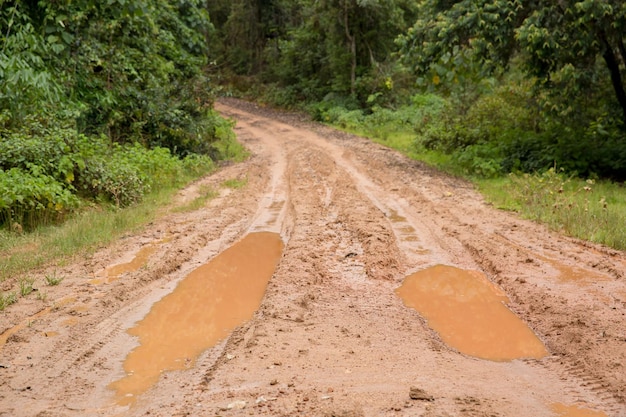 タイ北部のチェンマイの泥だらけの湿った田舎道トラックトレイル泥道森林自然農村風景茶色の粘土の水たまり道輸送国