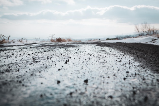 アスファルトで覆われていない泥だらけの濡れた道路