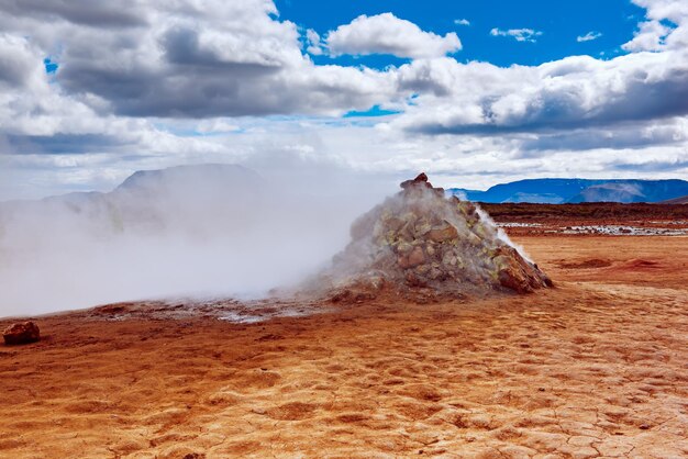 Photo mudpots in the geothermal area hverir iceland the area around the boiling mud is multicolored and cracked