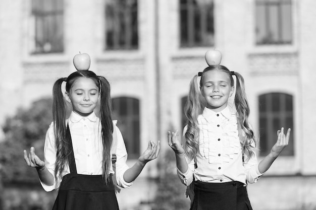 Mudra om je angstige geest te kalmeren gelukkige kinderen houden handen in mudra klein meisje mediteren met appels op hoofd schoolsnack handmudra symbolisch gebaar yoga mudra meditatie en asana