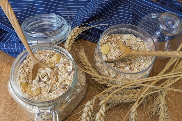 muesli, breakfast cereal, oatmeal in a glass container on a wooden table. rustic food.