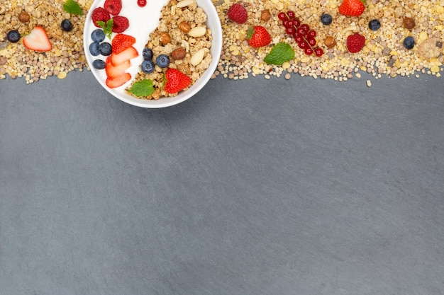 Muesli breakfast fruits yogurt strawberries cereals berries bowl slate copyspace top view