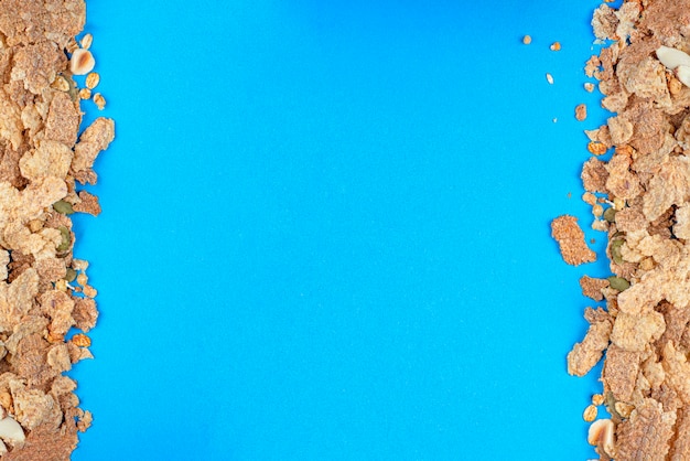 Muesli closeup of muesli scattered on a table breakfast cereals on a blue background healthy food ba...