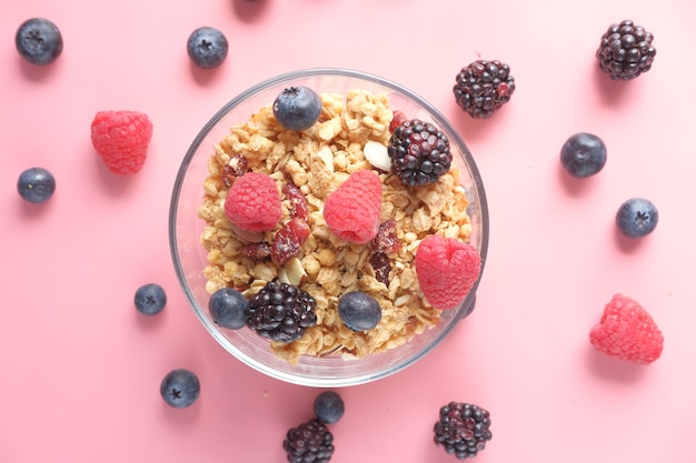 Muesli en bessen in kom op roze bureau