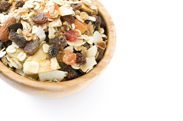 Muesli en gedroogd fruit in kom op wit wordt geïsoleerd dat