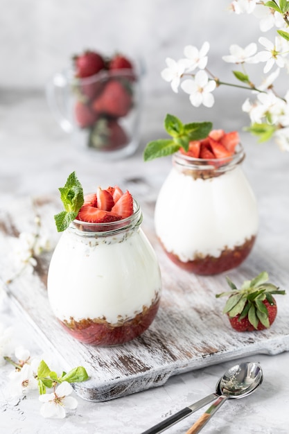 Muesli met yoghurt en aardbeien in een glazen pot.