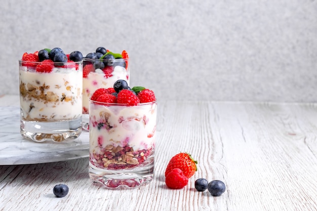 Muesli met yoghurt en bessen in een glas op een witte achtergrond