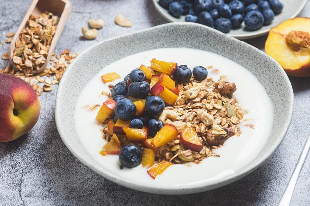 Muesli met yoghurt perzik bosbessen in een bord