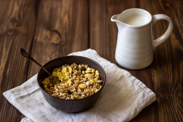 Muesli and milk jug on a wood