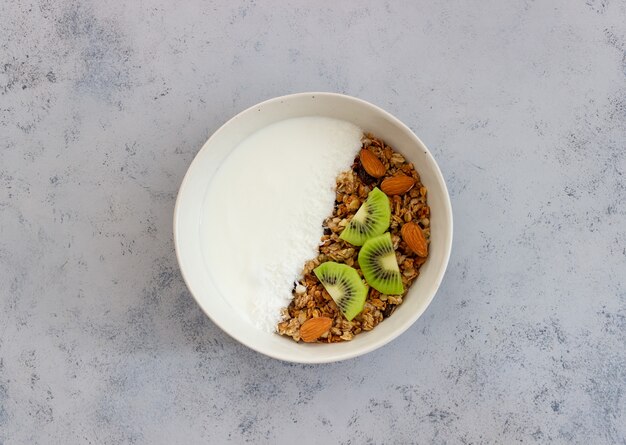 Muesli with white yogurt, kiwi and coconut flakes