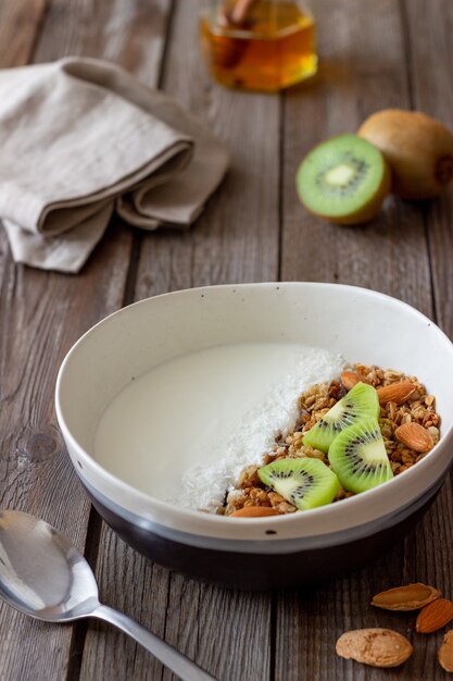 Muesli with white yogurt, kiwi and coconut flakes