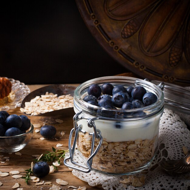 Muesli with yogurt and blue berries in glass jar.