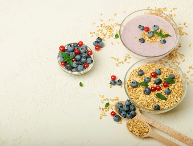 Muesli yoghurt bosbessen in kommen op grijze achtergrond Gezond ontbijt menu concept