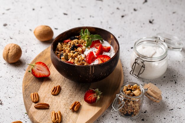 Muesli yoghurt met aardbeien en chiazaadjes op het houten bord