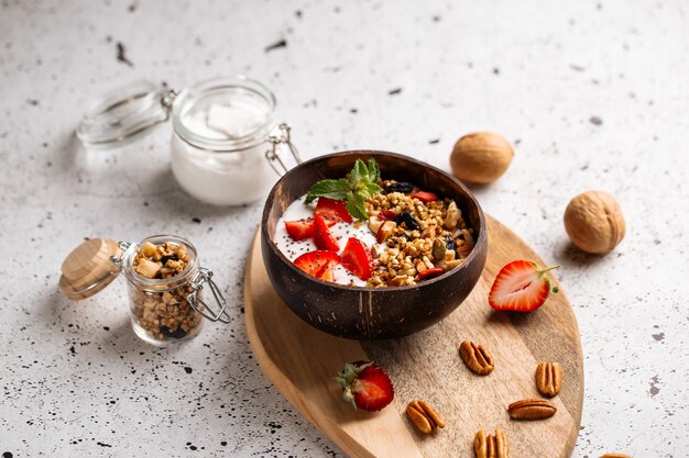 Muesli yoghurt met aardbeien en chiazaadjes op het houten bord