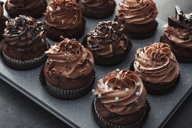 Muffin blik met smakelijke chocoladekoekjes op grijze achtergrond