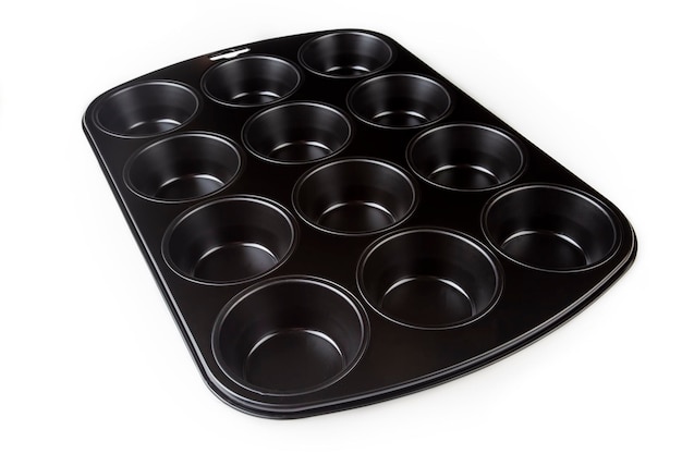 Muffin cake pan with nonstick coating isolated on a white background 12cup muffin baking tray Empty cupcake bake ware for pie tart cake and pastries concepts Kitchen utensils Top view