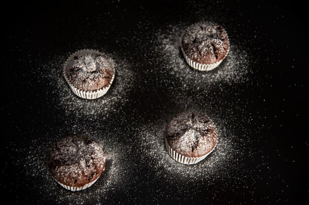 Muffin dessert op zwart met suikerpoeder