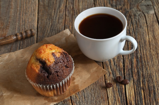 Muffin en kopje koffie op houten tafel