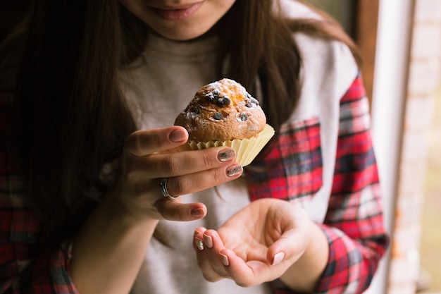 Photo muffin on girl hands. close up.