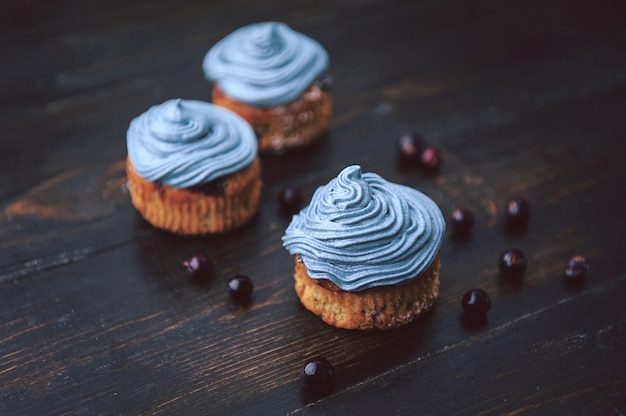 Muffin met aalbessen op een donkere achtergrond naast de bessen op de takken. in rustieke stijl. donkere stijl