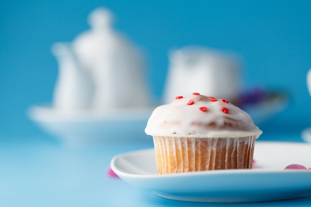 Foto muffin met glazuur op een bord en een mok