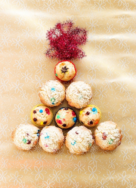 Muffin met kleurrijke chocolade en kopje zwarte thee Gouden feestelijke achtergrond Bovenaanzicht