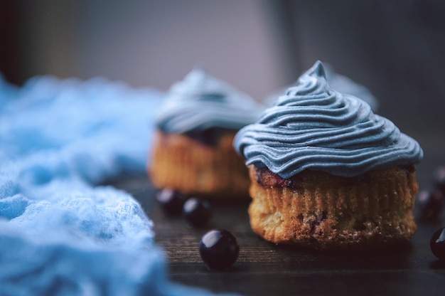 Muffin with currants on a dark background next to the berries on the branches. in a rustic style. dark style