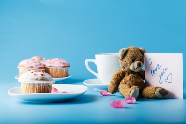 Muffin with icing on a plate and a mug