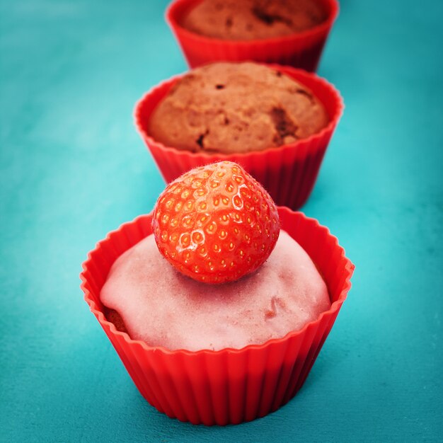 Muffin with strawberry in red holders