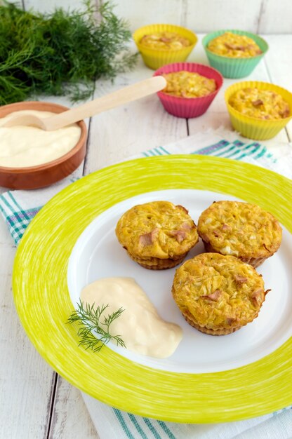 Muffins from cabbage with ham and cheese. Sour cream sauce.