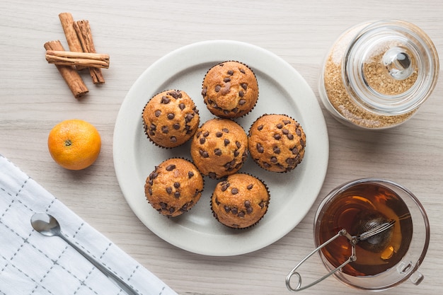 Muffins, kopje thee, suiker, mandarijn en kaneel