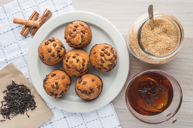 Foto muffins, kopje thee, thee, suiker, mandarijn en kaneel