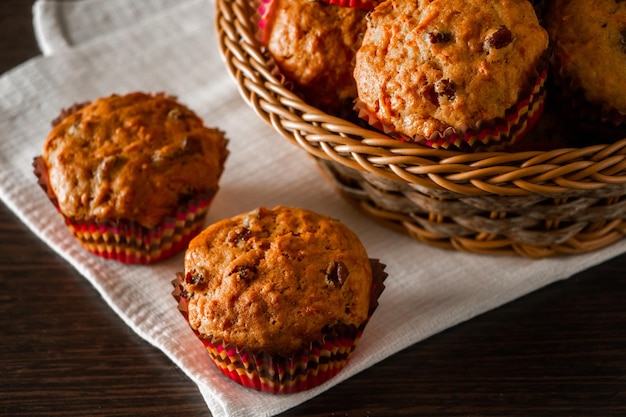 Muffins met rozijnen op een houten ondergrond Cupcake in een papieren mal op een wit servet