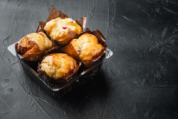 Muffins in plastic, container box, on black